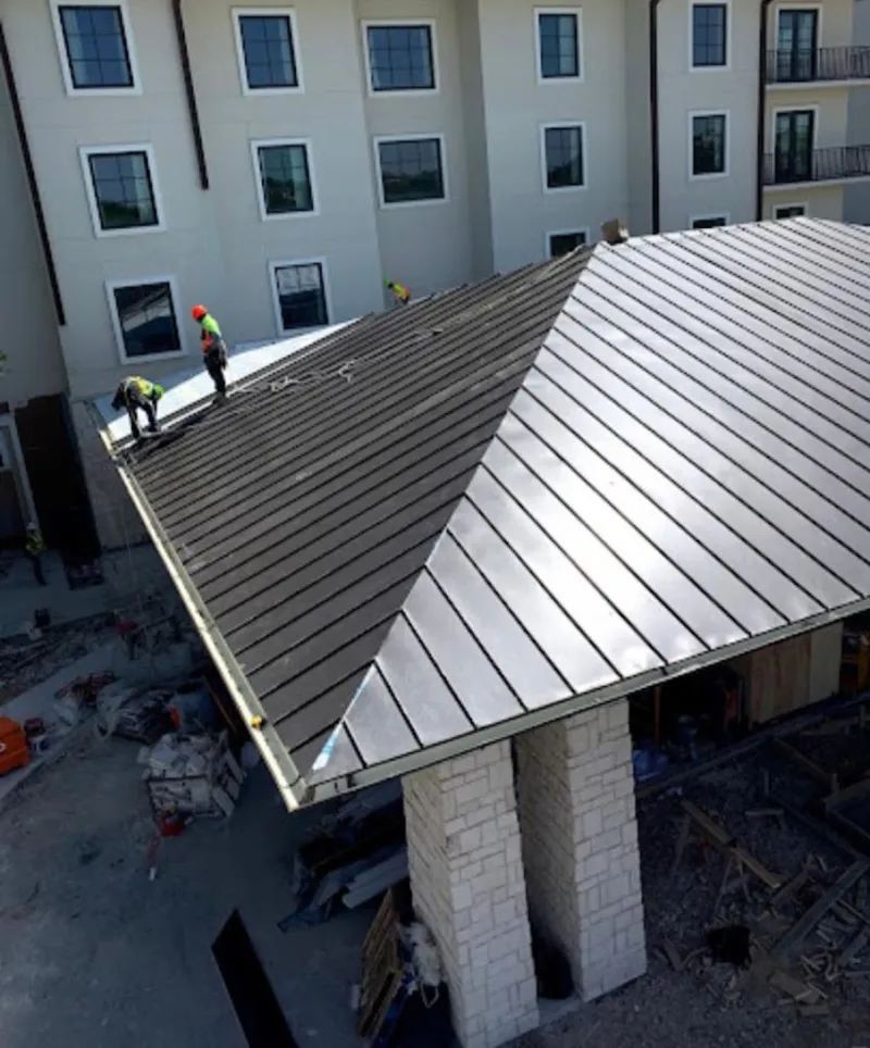Crew installing standing seam metal roof panels on a commercial project in Santee